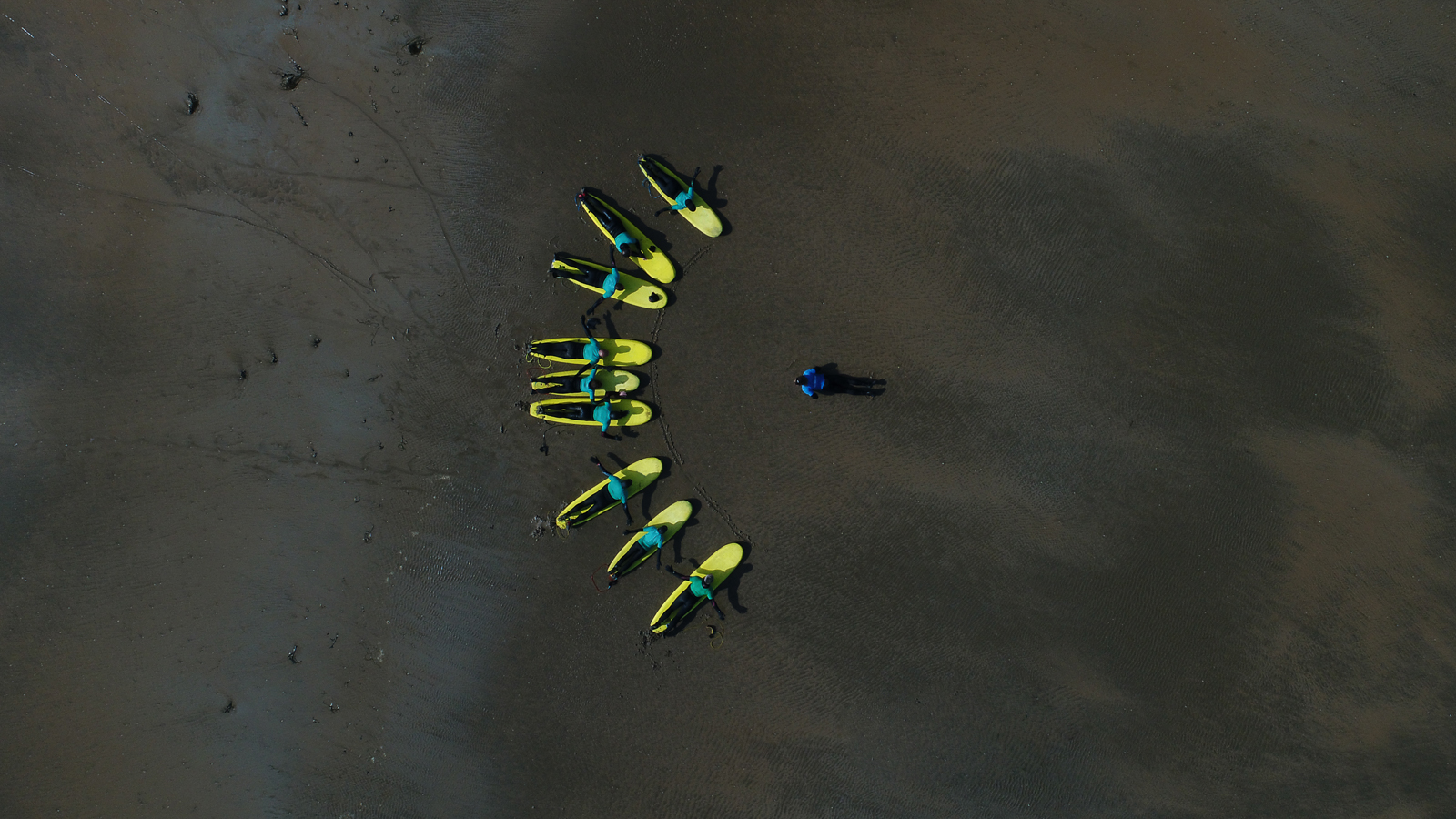 Aerial View of a group surfing lesson in progress, on the beache